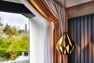 une lampe jaune et noire suspendue à une fenêtre dans l'établissement Hotel Zugbrücke Grenzau GmbH, à Höhr-Grenzhausen