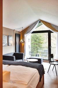 Cette chambre d'hôtel comprend un lit et un balcon. dans l'établissement Hotel Zugbrücke Grenzau GmbH, à Höhr-Grenzhausen