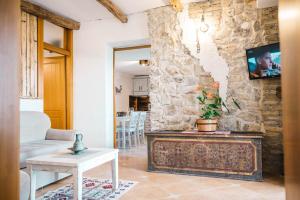 a living room with a couch and a tv on a stone wall at Apartments Bazar in Ulcinj