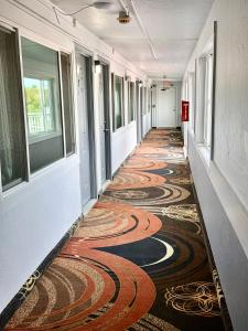 an empty hallway with a carpeted floor and windows at Eastern Inn in Bourne