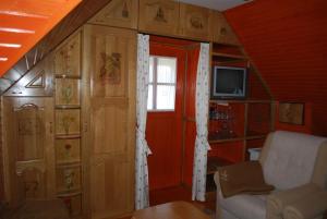 Cette chambre est dotée d'un mur rouge avec une porte et d'une télévision. dans l'établissement Apartma Mihovc, à Kamnik