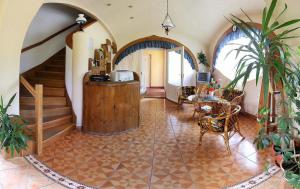 a living room with a staircase and a table and chairs at Fodor Hotel in Gyula