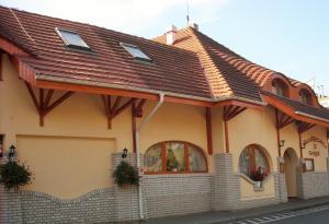 a house with a tiled roof on a street at Fodor Hotel in Gyula