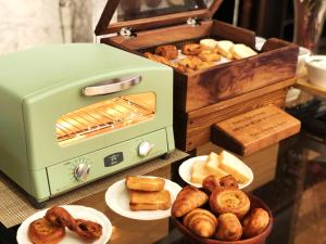 un tostapane verde seduto su un tavolo con piatti di pane di Hotel Monterey Kyoto a Kyoto