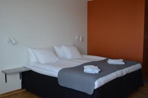 Bett in einem Zimmer mit weißer Bettwäsche und Kissen in der Unterkunft Forskarhotellet in Lund