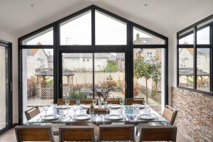 comedor con mesa, sillas y ventanas grandes en Villa Sainte Geneviève, en Saint-Malo