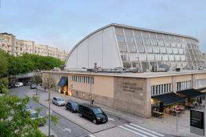 un grand bâtiment avec des voitures garées dans un parking dans l'établissement Hotel da Música, à Porto