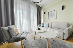 sala de estar con sofá y mesa en Sea Breeze Apartment, en Dziwnówek