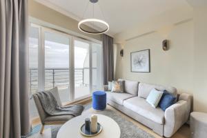 sala de estar con sofá y mesa en Sea Breeze Apartment, en Dziwnówek