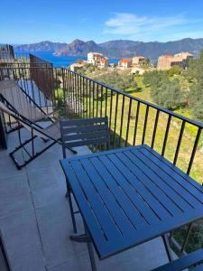 una mesa de picnic azul y sillas en un balcón con vistas en Appartement de standing piana, en Piana