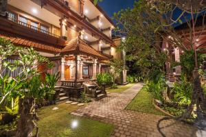 an exterior view of a house with a courtyard at Suka Beach Inn in Kuta