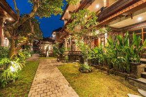 an exterior view of a house with a garden at Suka Beach Inn in Kuta