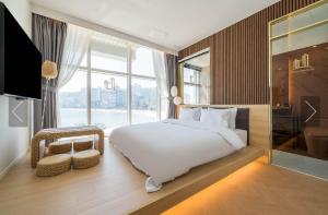 1 dormitorio con cama grande y ventana grande en De Homme Hotel, en Busan