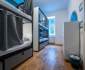 two bunk beds in a room with a wooden floor at The MadHouse Prague in Prague