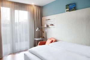 een hotelkamer met een bed en een raam bij greet Wien City Nord in Wenen