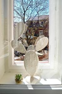 ein Fenster mit einer Blumenstatue davor in der Unterkunft Altbau-Traum im Stadtzentrum in Graz