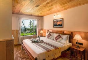 een slaapkamer met een groot bed en een raam bij Willow Hill by Nature Resorts in Ooty