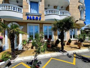 un grande edificio con palme di fronte di Family Hotel Paros a Pomorie