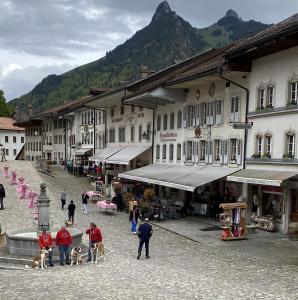 eine Gruppe von Menschen und Hunden in einer Stadt mit Gebäuden in der Unterkunft Gruyère Rooms in Gruyères