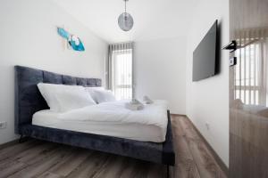 A bed or beds in a room at Villa Bauhaus Wellness Apartman 105