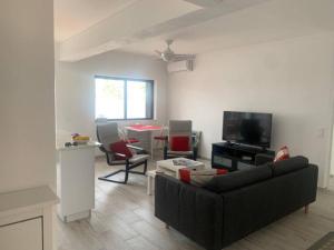 a living room with a couch and a tv at Nossa Casa - 2 Bedroom Apartment in Alvor in Alvor