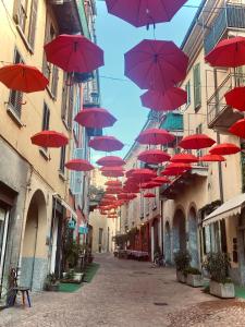 um monte de guarda-chuvas vermelhos pendurados numa rua em Appartamento Mia. Centro storico em Luino