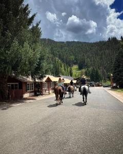 un groupe de personnes à cheval dans une rue dans l'établissement Three Bears Lodge, à Red River