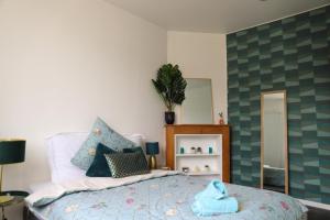 a bedroom with a bed with a blue towel on it at Très Belle MAISON à Rennes St Jacques in Saint-Jacques-de-la-Lande