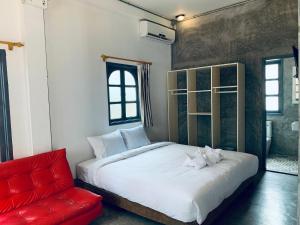 1 dormitorio con cama blanca y sofá rojo en La nuit de laos, en Luang Prabang