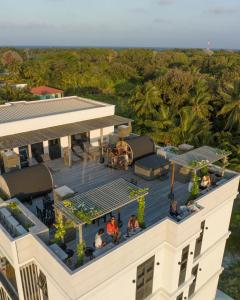 einen Ausblick über ein Gebäude mit Leuten auf dem Dach in der Unterkunft Ataraxis Grand and Spa Fuvahmulah in Fuvahmulah