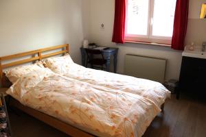 a bedroom with a bed and a desk and a window at A CÔTE in Môtiers