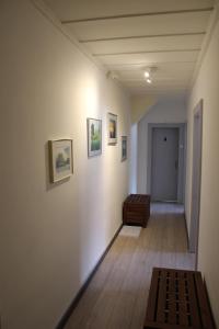 a hallway with a couch and paintings on a wall at A CÔTE in Môtiers