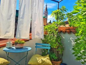 a blue table and chairs on a balcony with plants at Grisia 26 Apartment in Rovinj