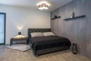 - une chambre avec un lit et un mur dans l'établissement Apartmány Na Lánech, à Litomyšl