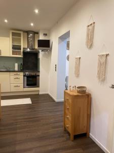 cocina con armarios blancos y mesa de madera en Ferienwohnung im BOHO Stil nähe Salzburg, en Freilassing