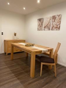 una mesa de madera y una silla en una habitación en Ferienwohnung im BOHO Stil nähe Salzburg, en Freilassing