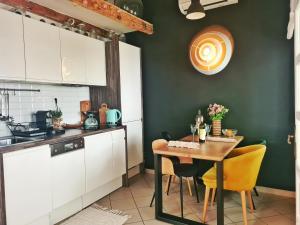 a kitchen with a table and chairs and a kitchen with green walls at Grisia 26 Apartment in Rovinj