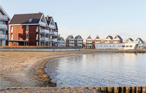 une rangée de maisons sur une plage à côté d'une étendue d'eau dans l'établissement Cozy Apartment In Rechlin With House Sea View, à Rechlin