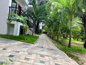 een geplaveide straat voor een huis met palmbomen bij Gatetrees resort in Jaffna