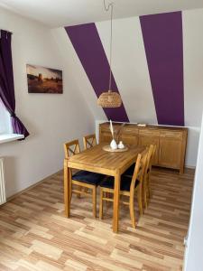 een eetkamer met een houten tafel en stoelen bij Ferienwohnung Friedrich Dorfmark in Bad Fallingbostel