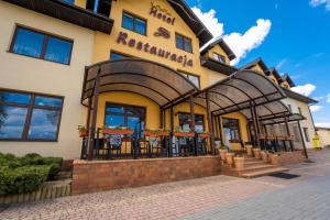 ein Hotel mit Tischen und Stühlen vor einem Gebäude in der Unterkunft Hotel Szelców in Lesko