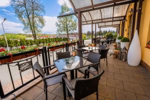 eine Terrasse eines Restaurants mit Tischen und Stühlen in der Unterkunft Hotel Szelców in Lesko