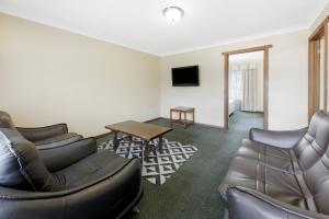 a living room with a couch and a table at Elizabethan Lodge in Melbourne