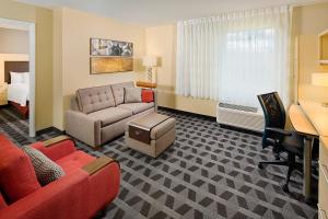 TownePlace Suites by Marriott Fayetteville N / Springdale في جونسون: غرفة في الفندق مع أريكة وسرير