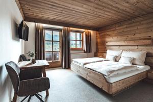 - une chambre avec un lit et un bureau dans l'établissement Hotel Chalets Grosslehen, à Fieberbrunn