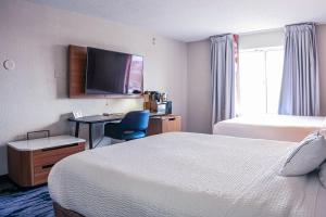 a hotel room with a bedroom with a bed and a desk at Fairfield Inn and Suites by Marriott Indianapolis/ Noblesville in Noblesville