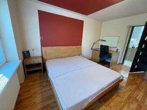 ein Schlafzimmer mit einem Bett und einem Schreibtisch. in der Unterkunft Apartman Bibi-D in Komárno