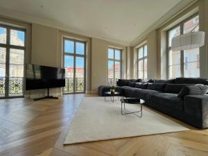 een woonkamer met een bank en een flatscreen-tv bij Luxury Home / 3-Raum-Suite an der Frauenkirche / 4 in Dresden