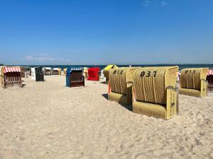 een groep stoelen en tafels op een strand bij Ferienwohnung 1 Zimmer App Ankerplatz 43 im Olympiazentrum in Kiel