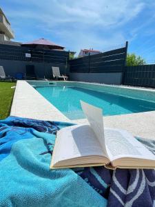 - un livre ouvert sur une couverture à côté de la piscine dans l'établissement Villa Fortuna, à Podstrana